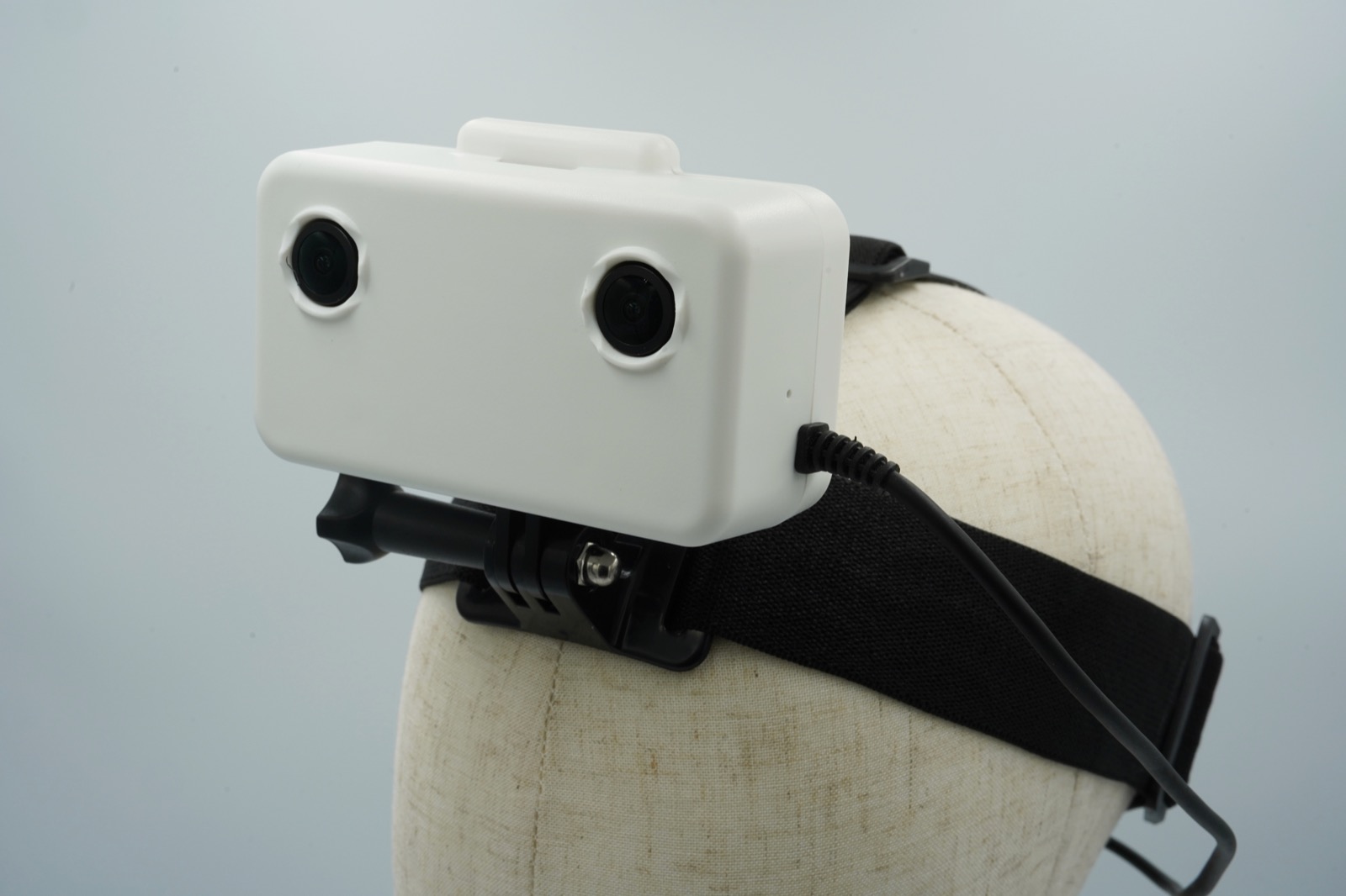 安装在头模上的 EGO1GS 头戴设备,展示全局快门立体摄像头对、GoPro 式支架和弹性头带